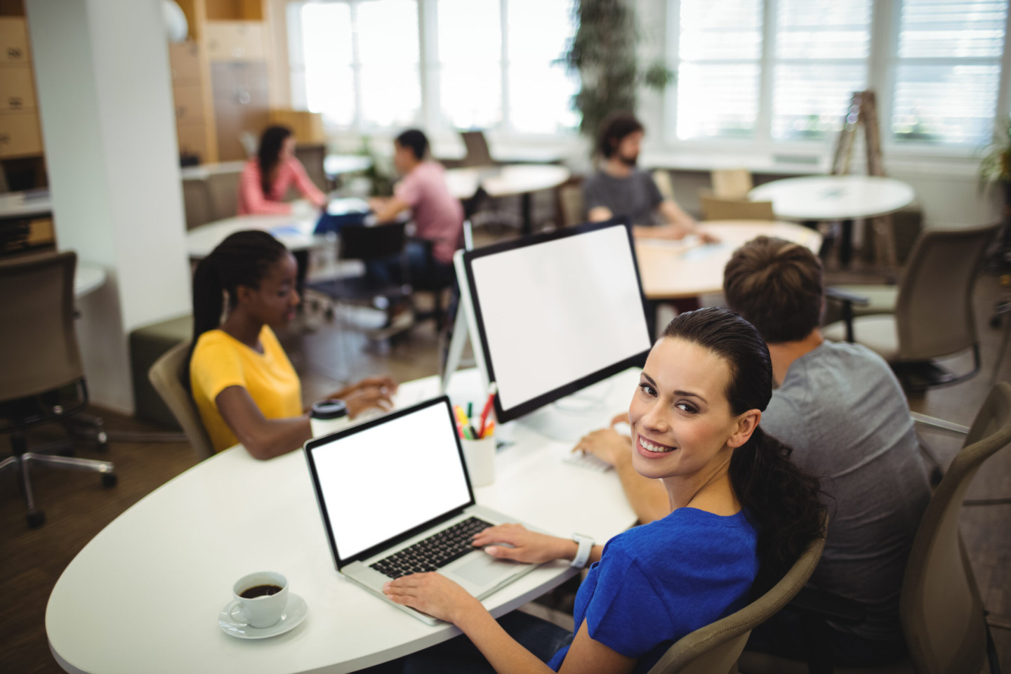 Portrait of woman using laptop at her desk